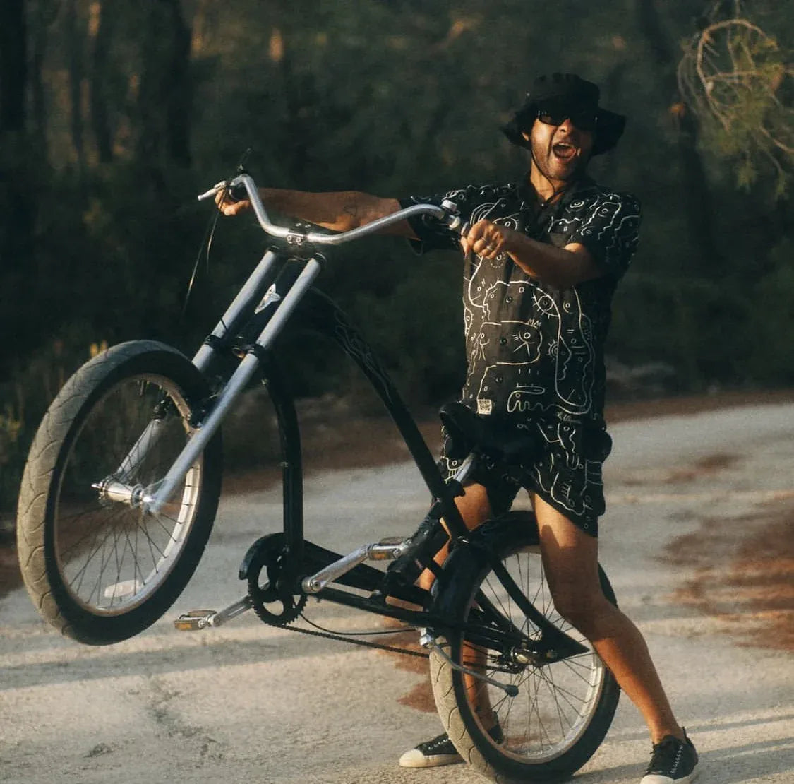 George Evelyn wearing a black UKENA work while lifting the front wheel of a bicycle