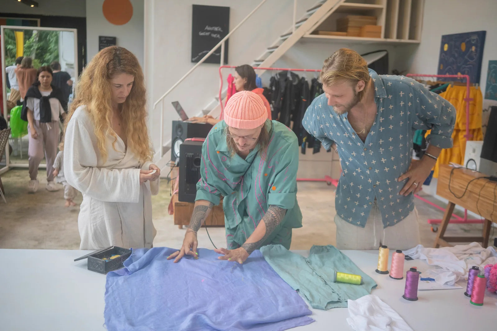 Participants drawing across a pale blue garment together