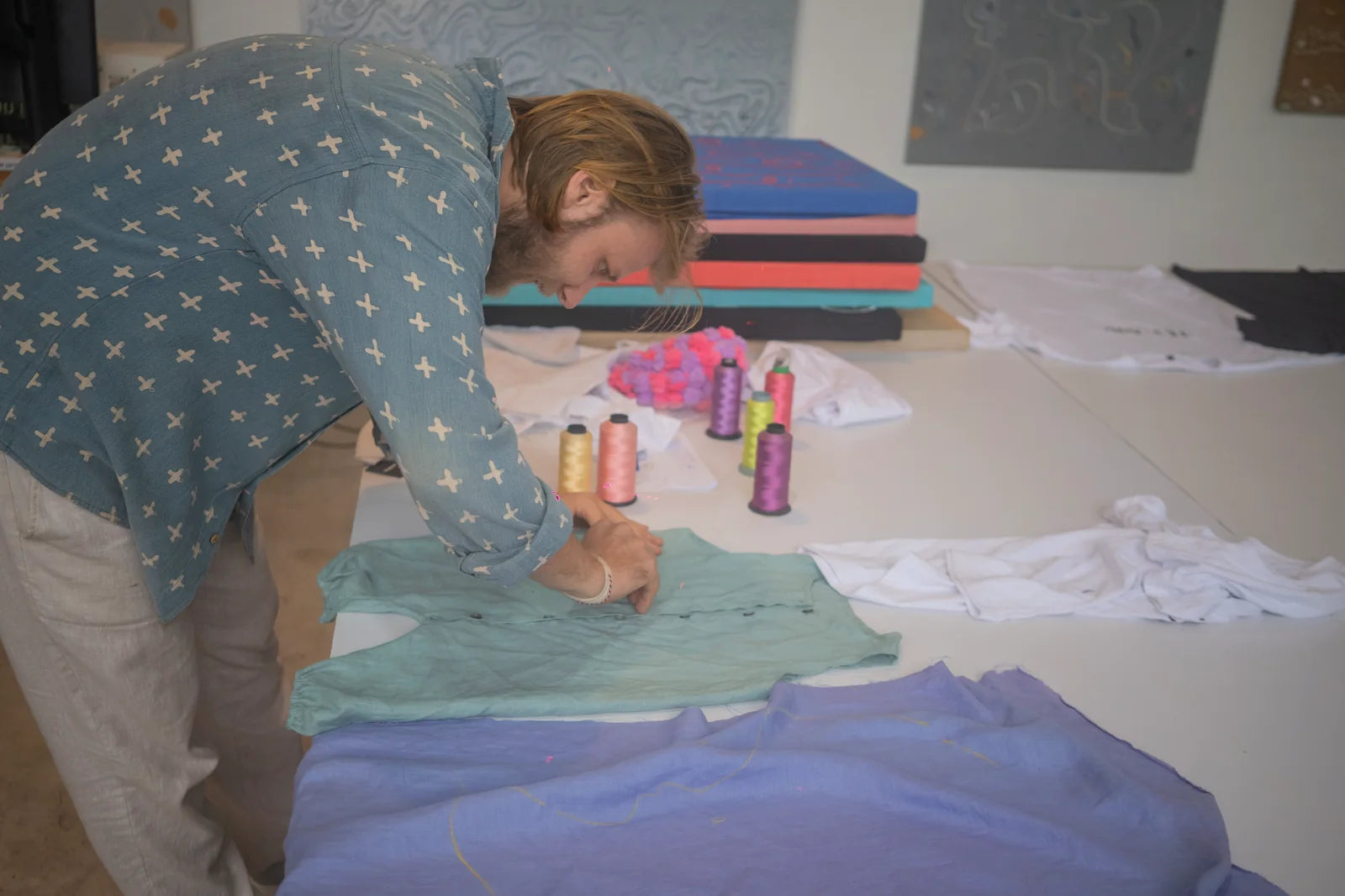 A participant drawing across several coloured garments