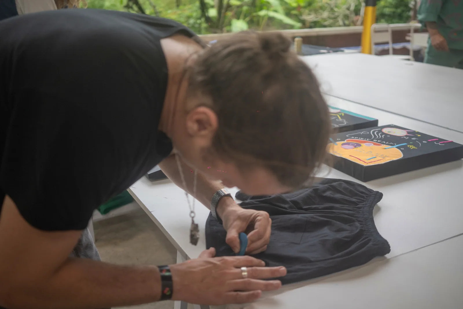 A close view of a hand drawing onto black fabric