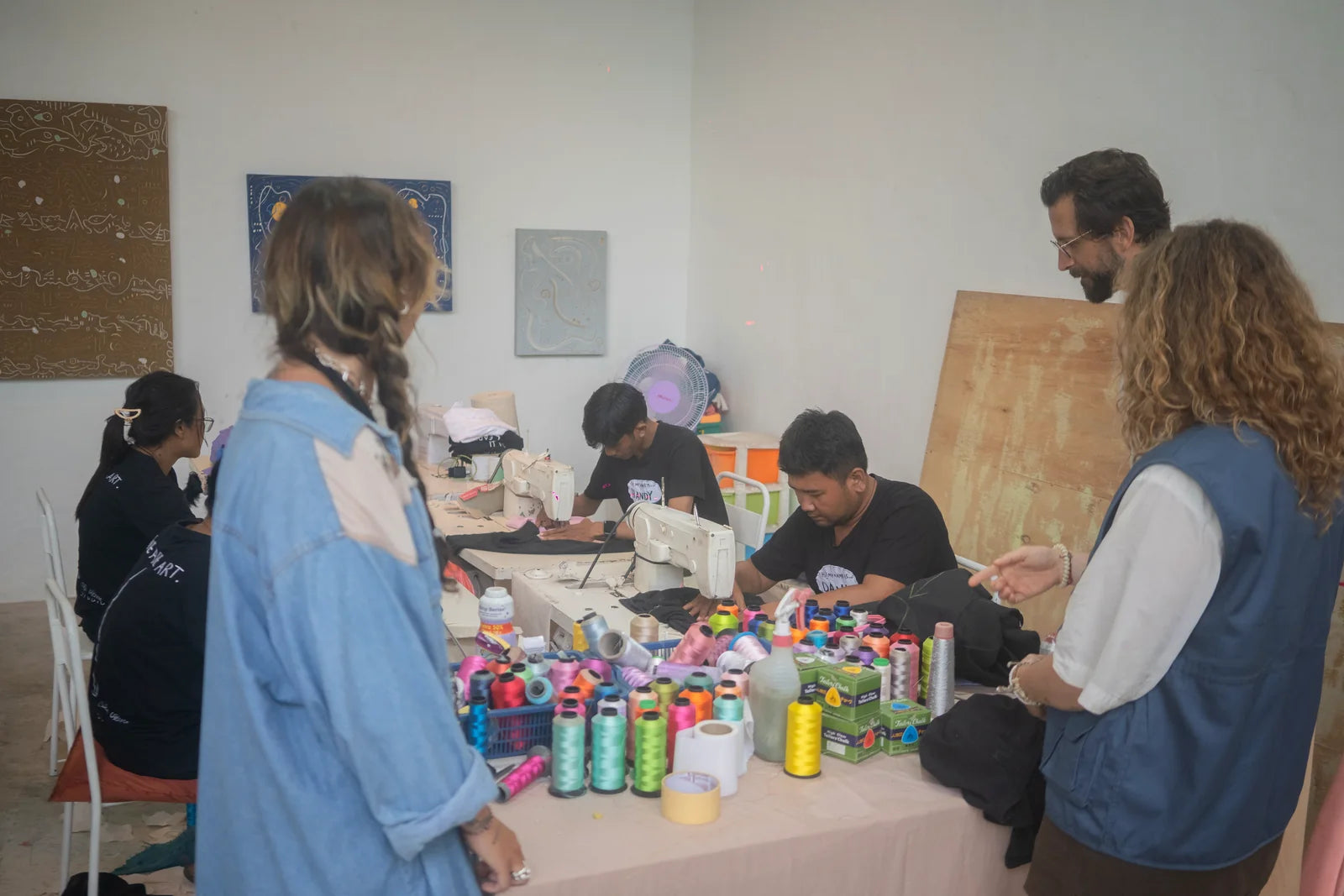 The open studio table surrounded by participants and thread