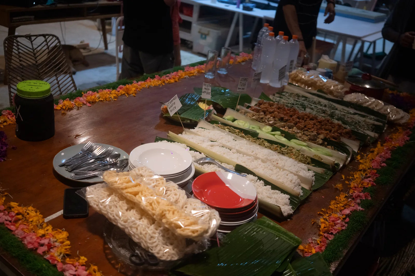 The shared meal laid across banana leaves and flowers