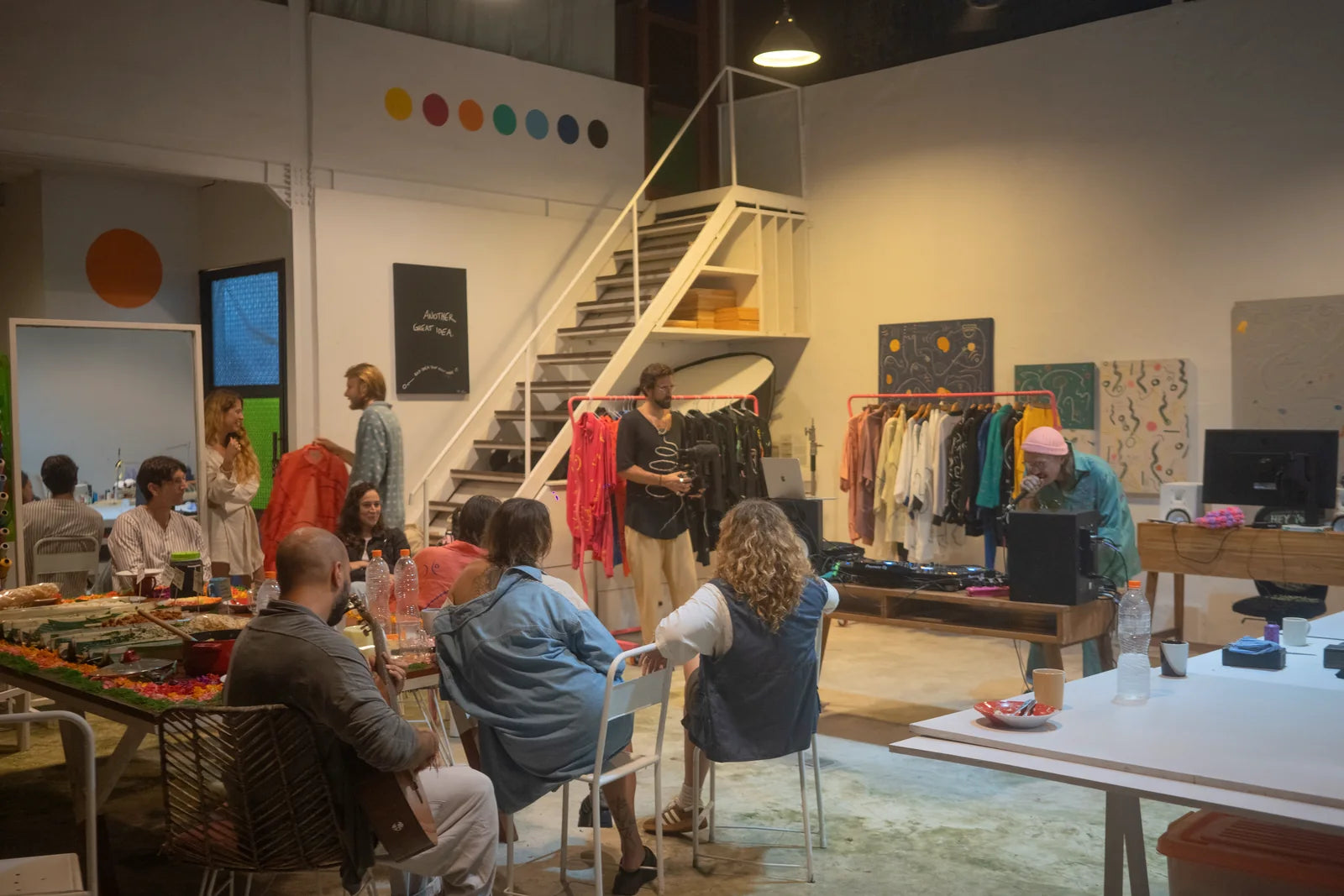 Guests seated among garments, artworks and the working tables