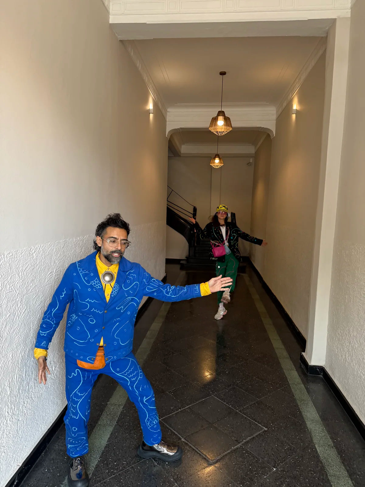 Varun posing playfully in a blue embroidered suit