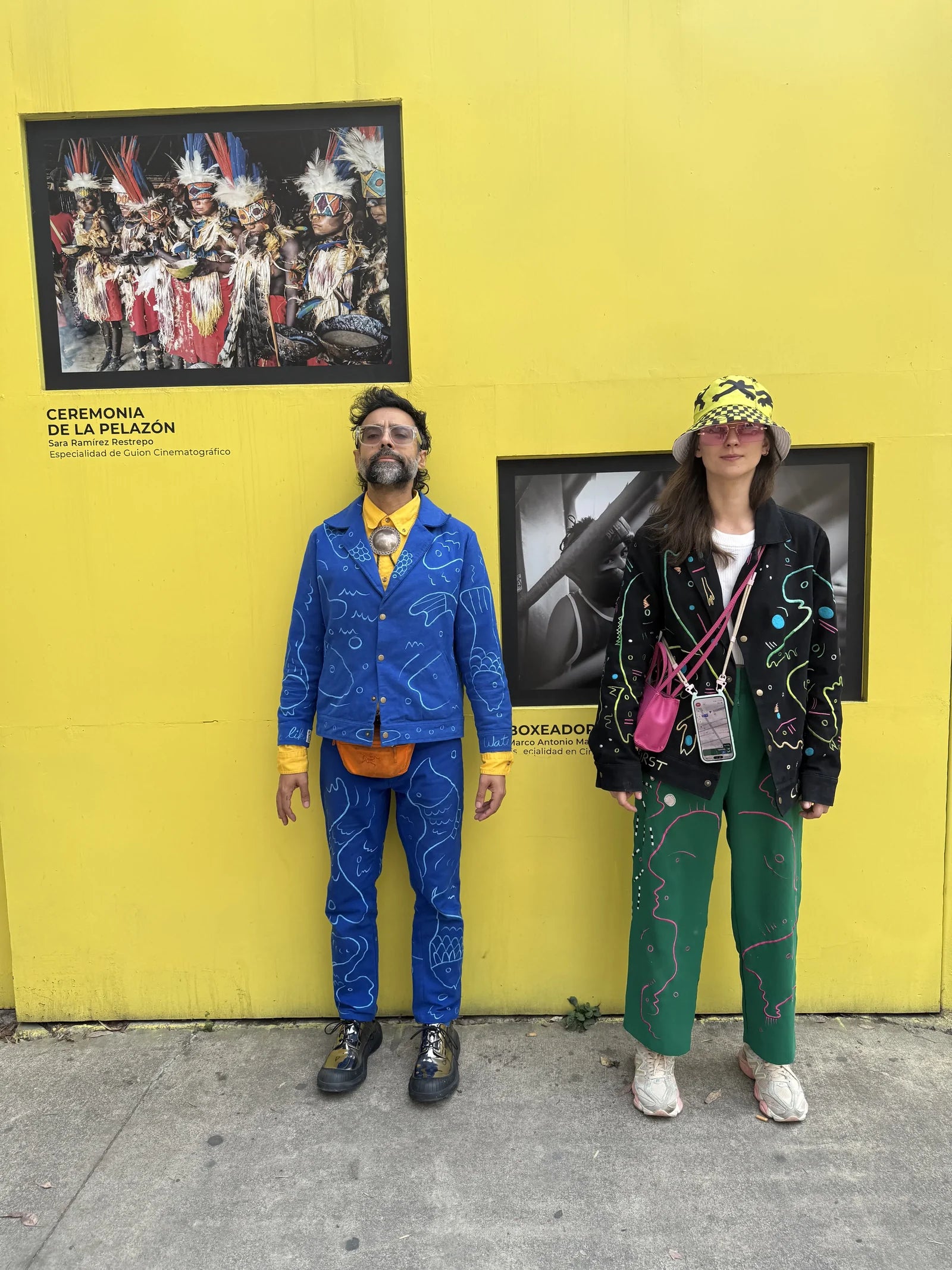 Varun and Morta wearing UKENA works against a yellow wall in Mexico City