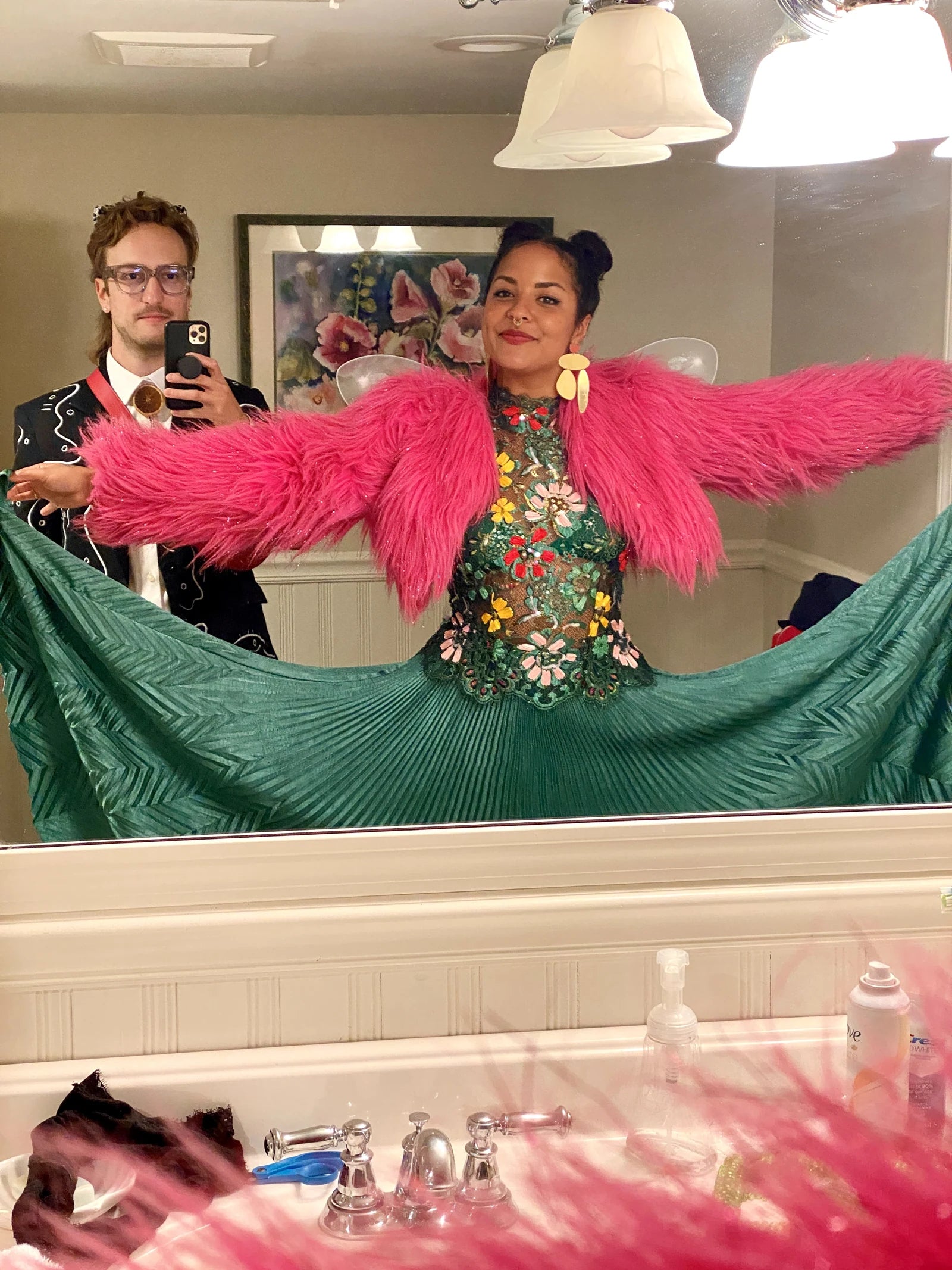 Forrest and Michelle in a mirror, with the embroidered wedding suit and pink feathered jacket
