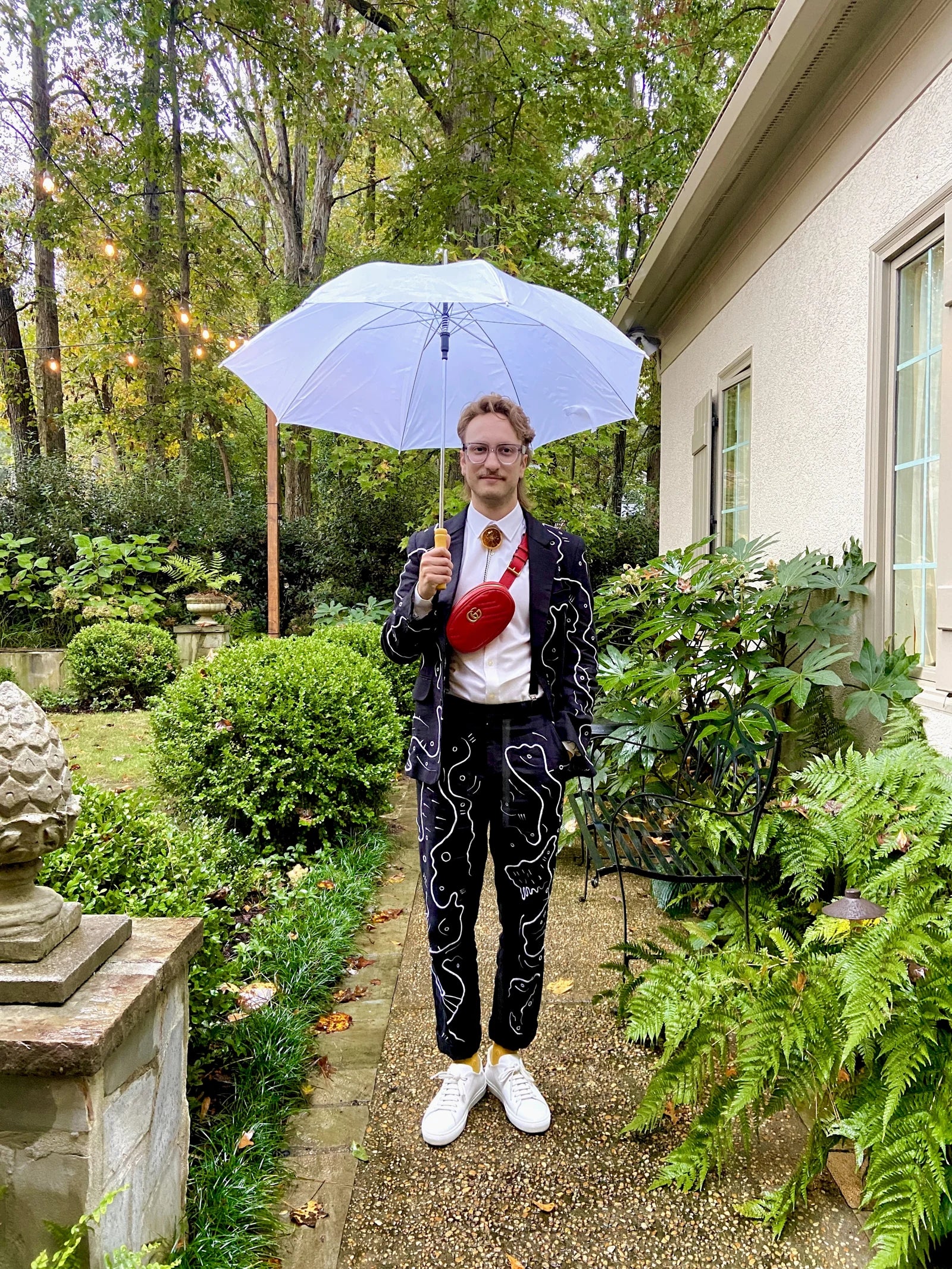 Forrest Aguar in the embroidered suit with a light umbrella