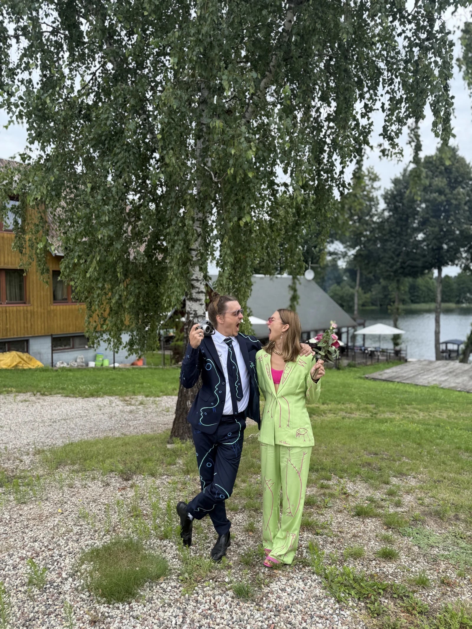 Ole and Morta walking together in custom UKENA suits at a wedding in Lithuania
