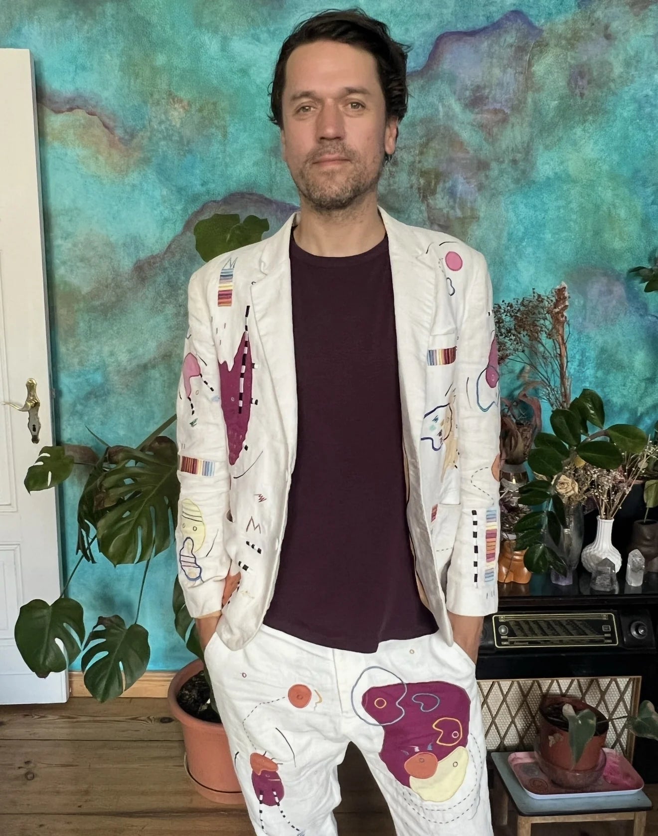 Nico Stojan in a sharp portrait wearing a white hand-drawn UKENA suit