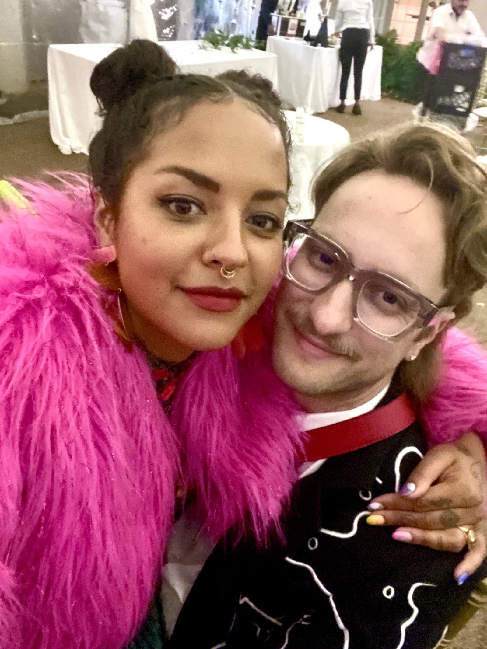 Michelle Norris and Forrest Aguar together, with pink feathers and the embroidered wedding suit