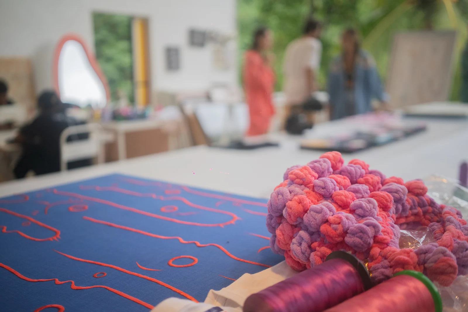 Pink thread and embroidery on the studio worktable
